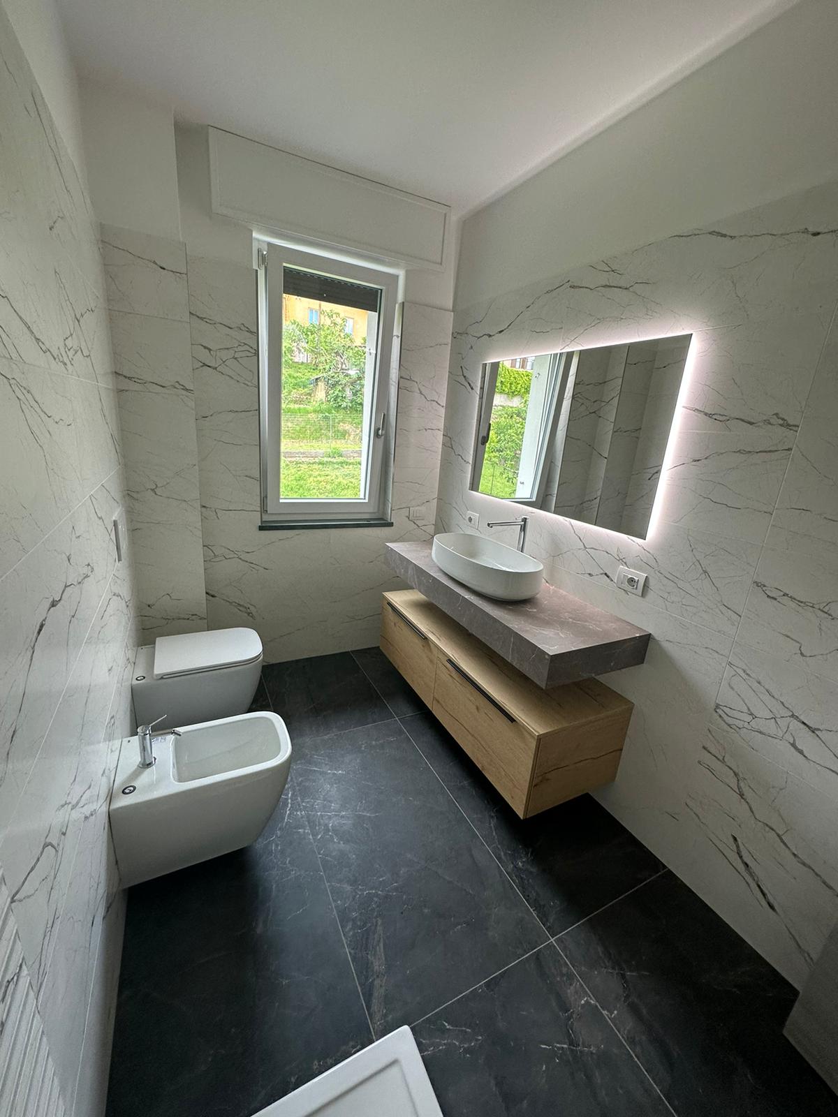 Bagno rivestito con grandi lastre effetto marmo